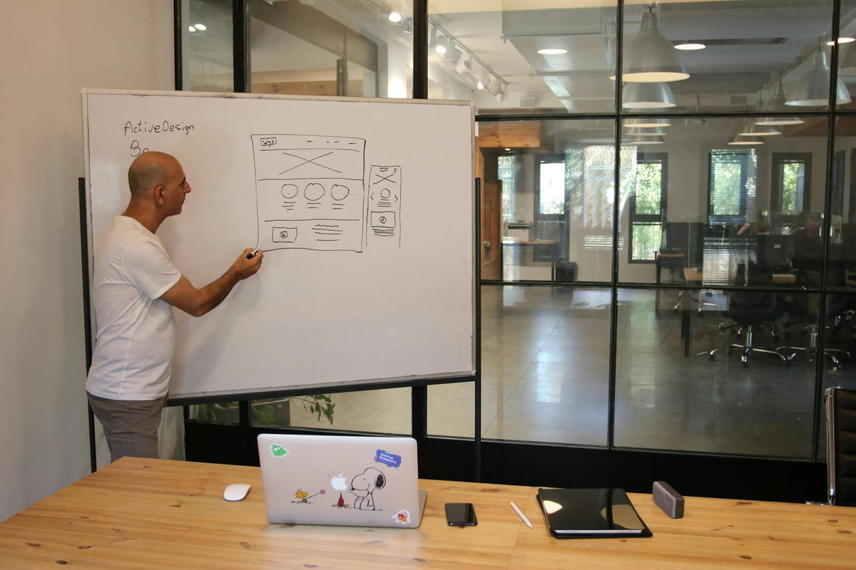 A man drawing on a whiteboard in an office