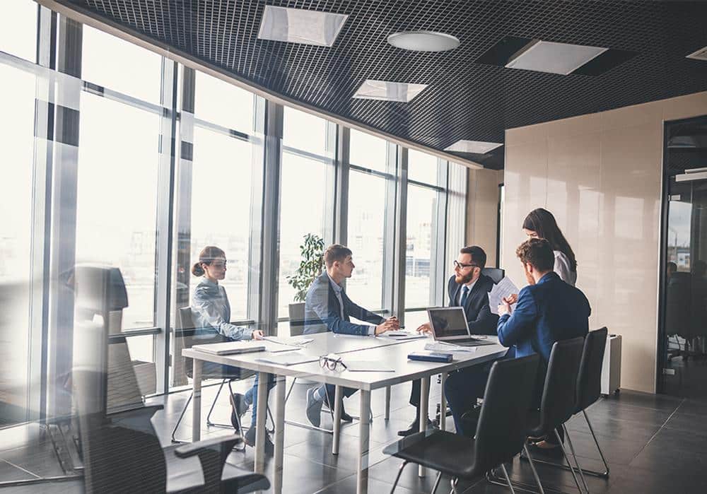 Business team holding a meeting around a table in a modern conference room.