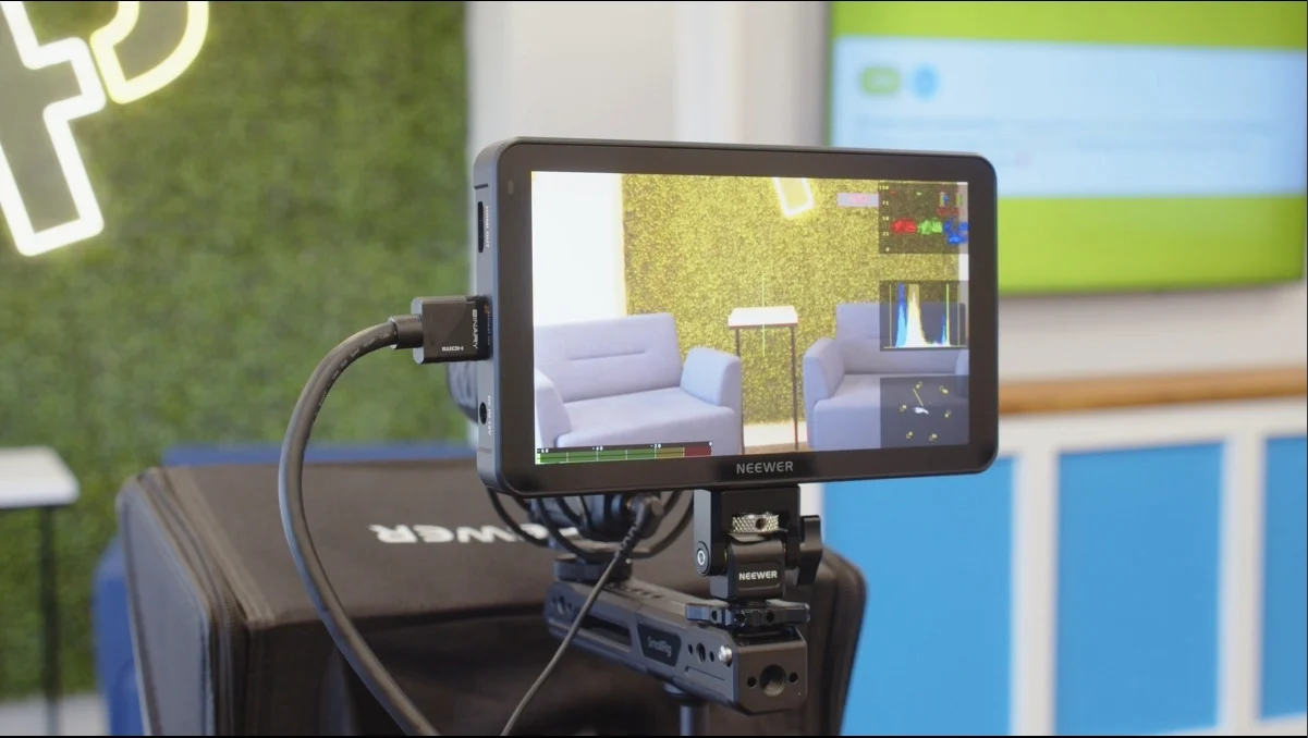 Camera monitor displaying two blue chairs in a studio.