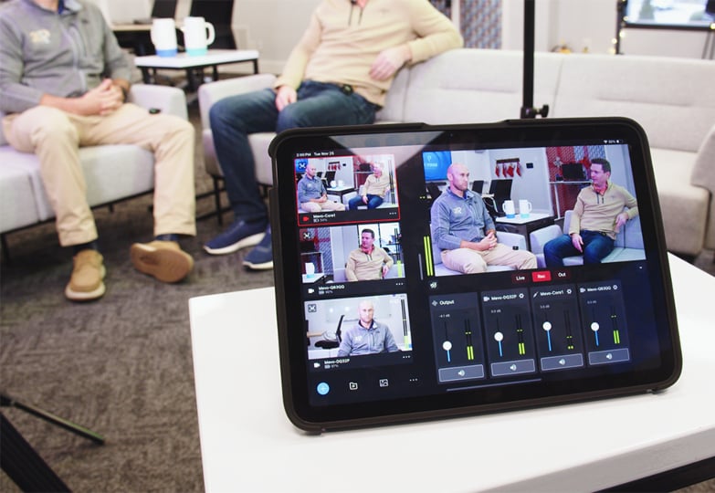 Tablet displaying video feeds of two men seated on couches.