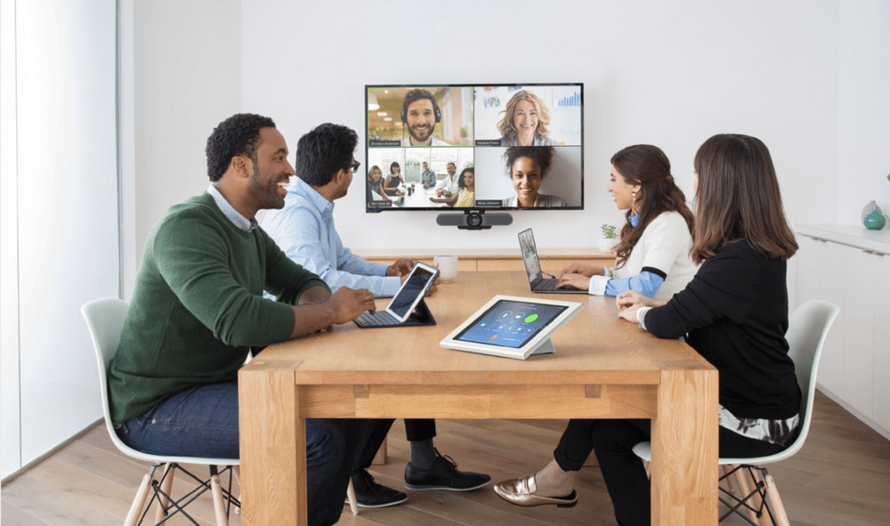Team using Zoom Rooms in a conference room with remote participants on screen