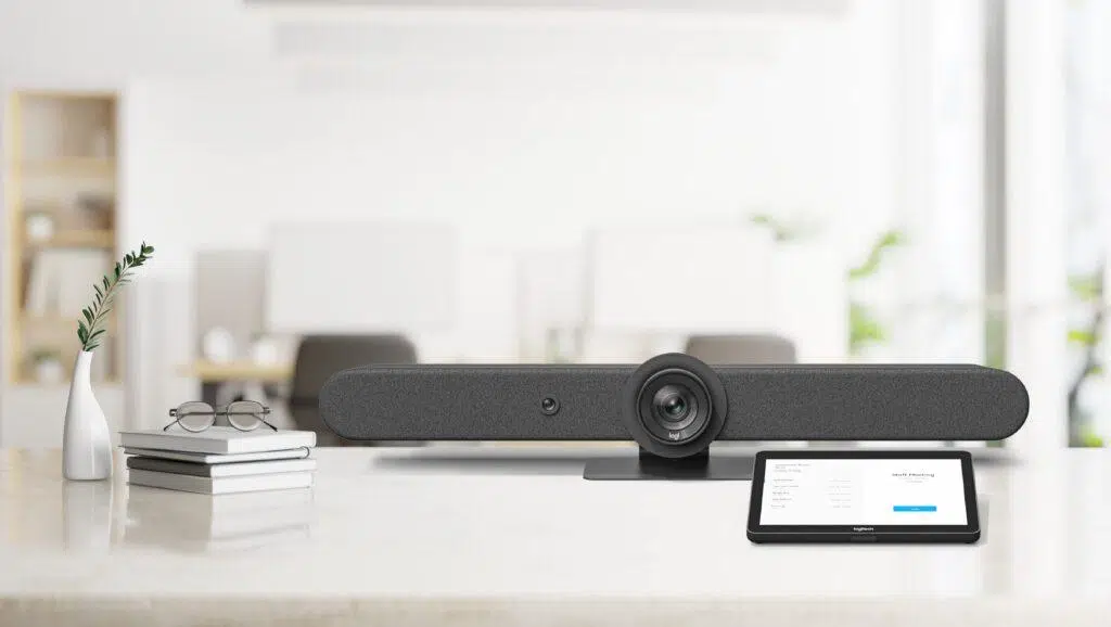 Video conferencing bar and touchscreen controller on a conference room table.