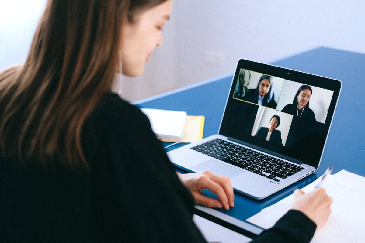 A woman meeting with a group of people in a video call